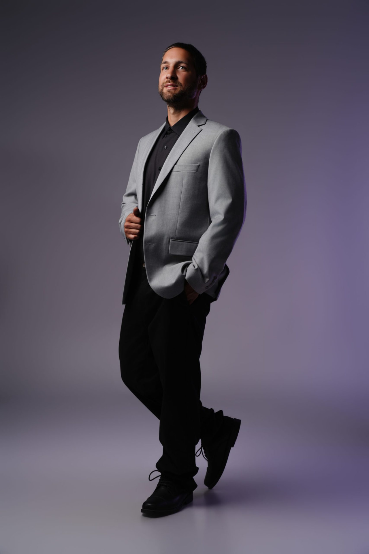 Justin Samuel Parsons standing in a grey suit jacket
