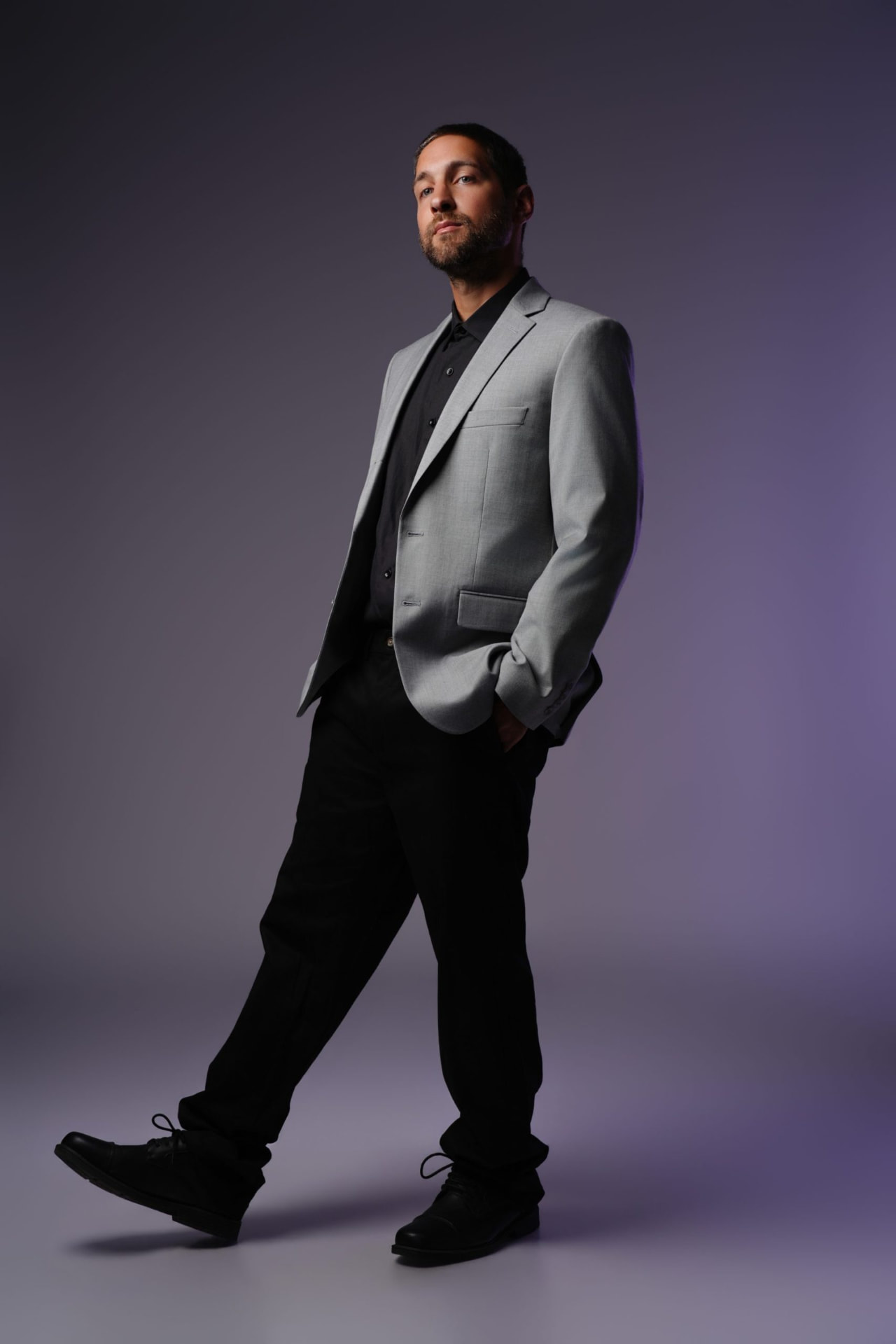 Justin Samuel Parsons walking in a grey suit